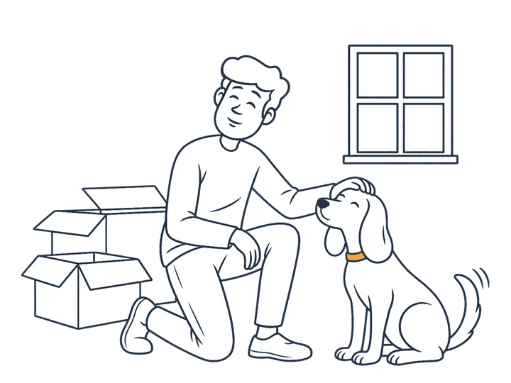 A person strokes their dog next to some moving boxes.